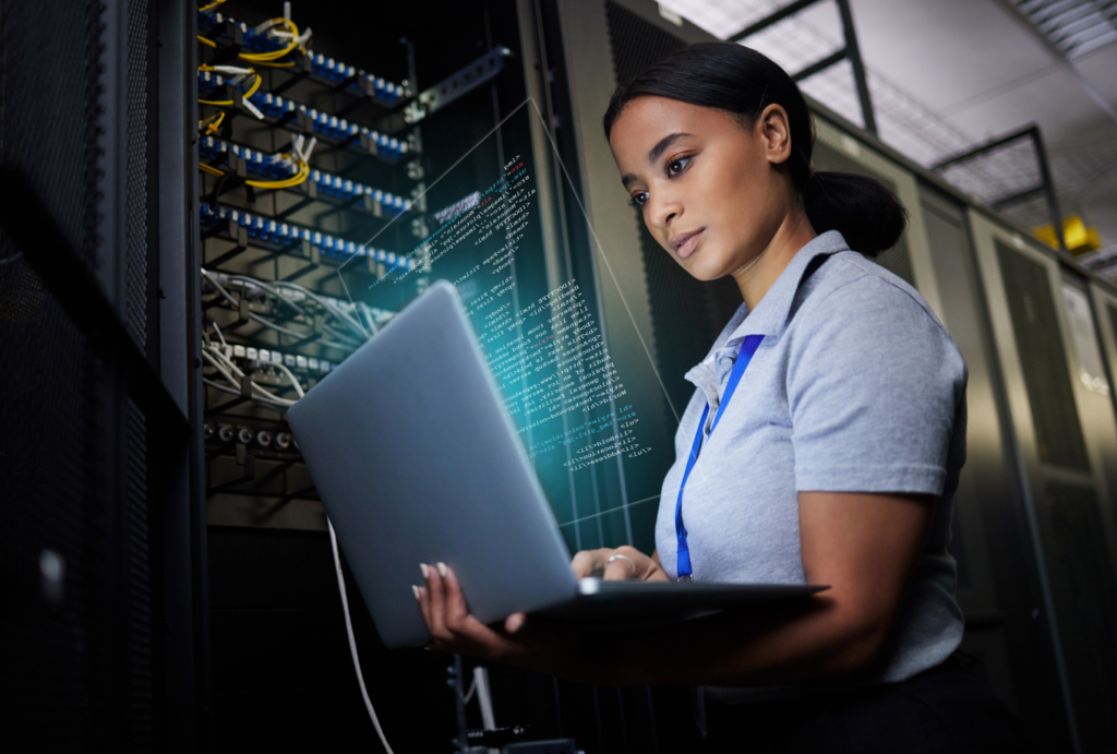 Frau arbeitet mit einem Laptop in einem Serverraum