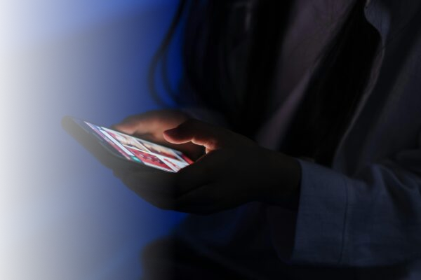 Person nutzt im Dunkeln ein Smartphone